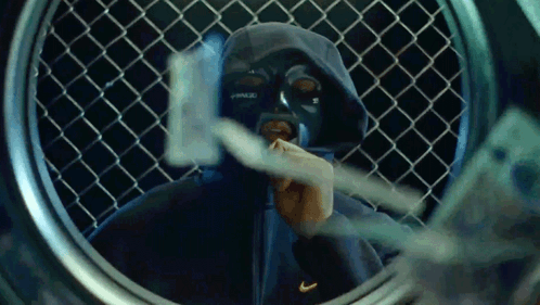 A Man Wearing A Mask And A Nike Hoodie Looks Through A Laundromat Window GIF