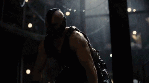 A Man Wearing A Mask And Gloves Is Laying On The Ground In A Dark Room GIF