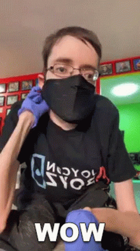 A Man Wearing A Mask And Gloves With The Word Wow Written On It GIF