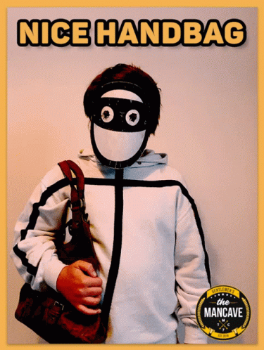 A Man Wearing A Mask And Holding A Purse With The Words Nice Handbag Written Above Him GIF