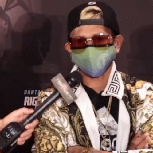 A Man Wearing A Mask And Sunglasses Is Being Interviewed By A Reporter From Fight Night Tv GIF
