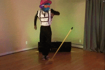 a man wearing a mask and sunglasses is dancing with a broom