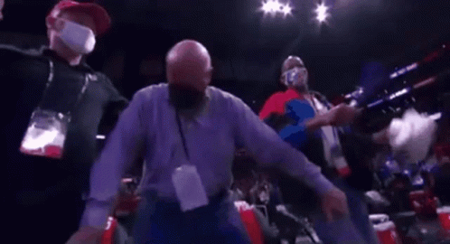 a man wearing a mask is dancing in a boxing ring .