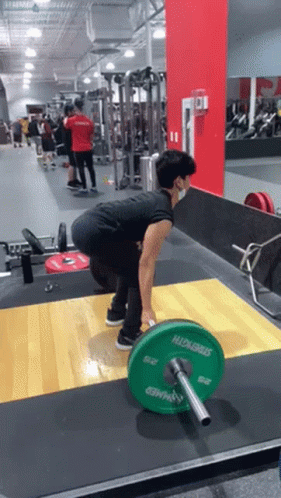 A Man Wearing A Mask Is Lifting A Green Barbell With The Word Strength On It GIF