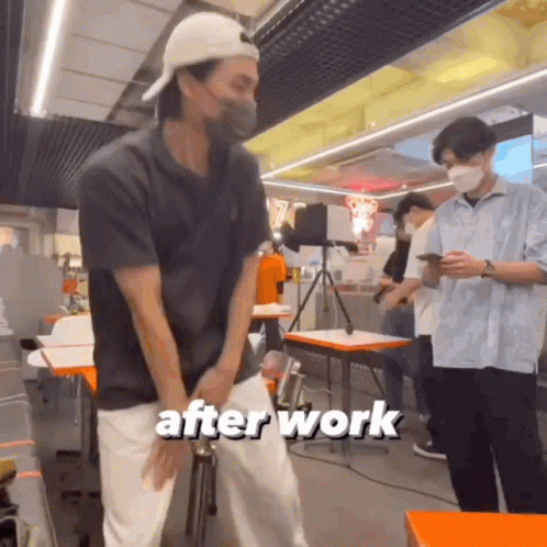 A Man Wearing A Mask Is Standing In A Restaurant With The Words After Work Written On The Bottom Of The Image . GIF