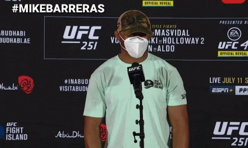 A Man Wearing A Mask Is Standing In Front Of A Ufc Sign GIF