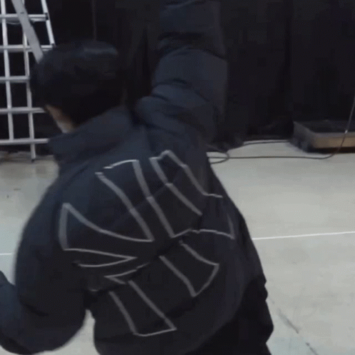 A Man Wearing A Mask Is Stretching His Arms While Another Man Looks On GIF