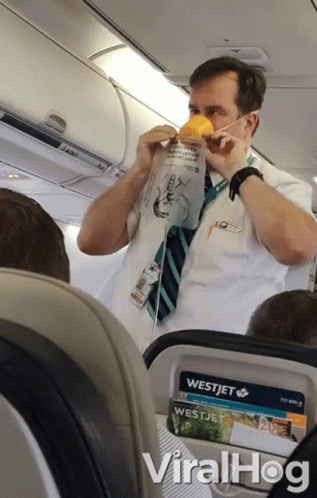 A Man Wearing A Mask On An Airplane With A Westjet Advertisement GIF