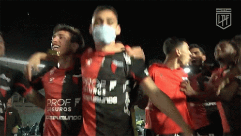 A Man Wearing A Mask Stands Next To A Man Wearing A Shirt That Says Prof Seguros On It GIF