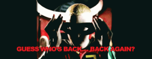 A Man Wearing A Mask With The Words Guess Who 'S Back Back Again Behind Him GIF