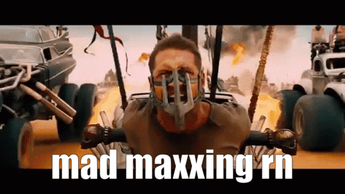 A Man Wearing A Mask With The Words Mad Maxxing Rn Written Below Him GIF