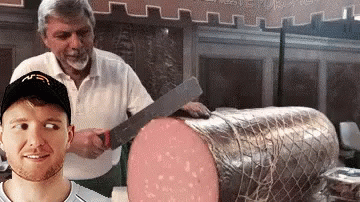 A Man Wearing A Mcdonald 'S Hat Is Standing Next To A Large Piece Of Meat GIF