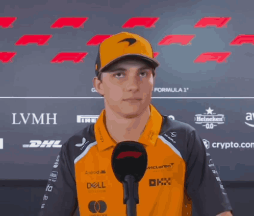 A Man Wearing A Mclaren Hat And A Dell Shirt Is Talking Into A Microphone GIF
