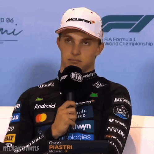A Man Wearing A Mclaren Hat Holds A Microphone GIF