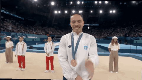 A Man Wearing A Medal Around His Neck With The Number 46 On It GIF
