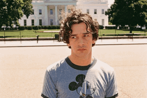A Man Wearing A Mickey Mouse T-Shirt Stands In Front Of The White House GIF