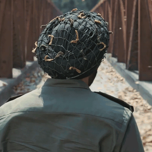 A Man Wearing A Military Uniform And A Helmet With A Net On It GIF