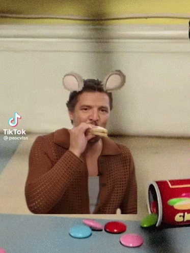 A Man Wearing A Mouse Ear Headband Eating A Snack GIF