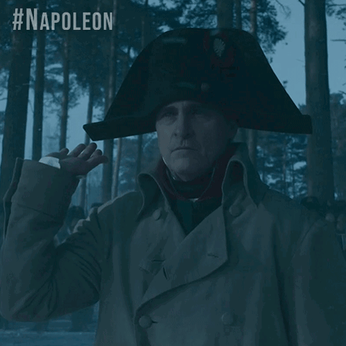 A Man Wearing A Napoleon Hat Stands In A Forest GIF