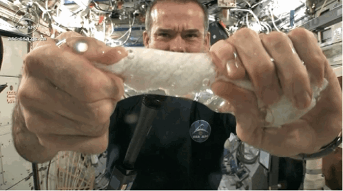 A Man Wearing A Nasa Shirt Is Holding A Piece Of Plastic GIF