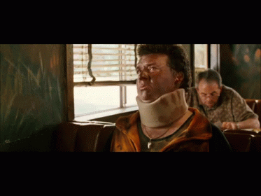 A Man Wearing A Neck Brace Sits At A Table In A Diner GIF