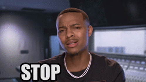 A Man Wearing A Necklace And A Black Shirt Is Saying Stop GIF