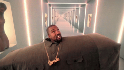 A Man Wearing A Necklace That Says ' Kanye West ' On It GIF