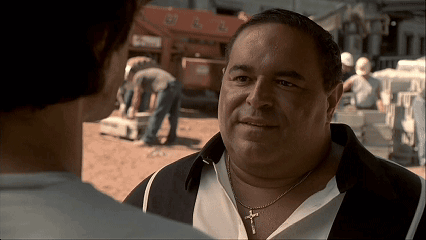 A Man Wearing A Necklace With A Cross On It GIF