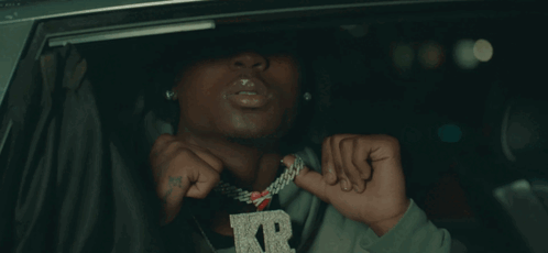 A Man Wearing A Necklace With A Letter R On It GIF