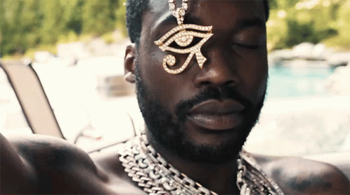 A Man Wearing A Necklace With An Eye Pendant GIF