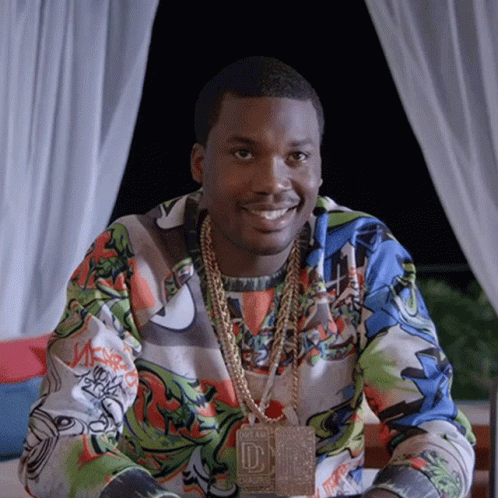 A Man Wearing A Necklace With The Letter D On It Smiles GIF