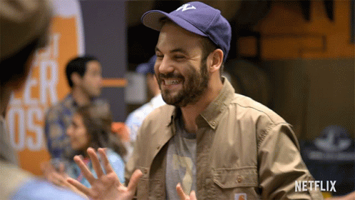 Man Smiling In Netflix Jacket And Hat GIF