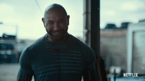 A Man Wearing A Netflix Shirt Is Smiling GIF