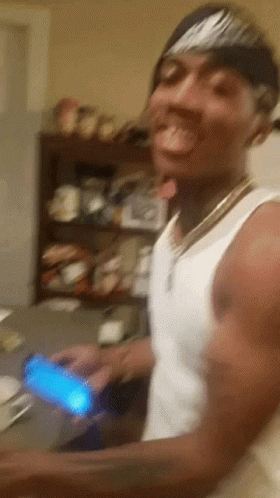 A Man Wearing A Nike Headband Is Holding A Cell Phone In His Hand GIF