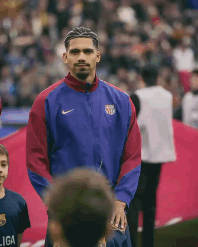 A Man Wearing A Nike Jacket Stands In Front Of A Crowd GIF