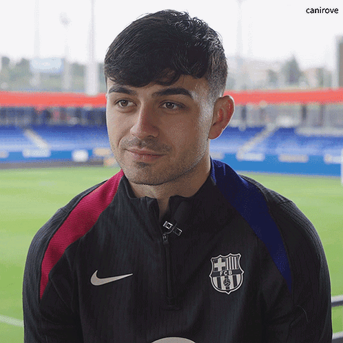 a man wearing a nike jacket with a fcb logo on the front