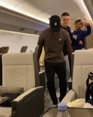 A Man Wearing A Nike T-Shirt Is Dancing On A Plane GIF