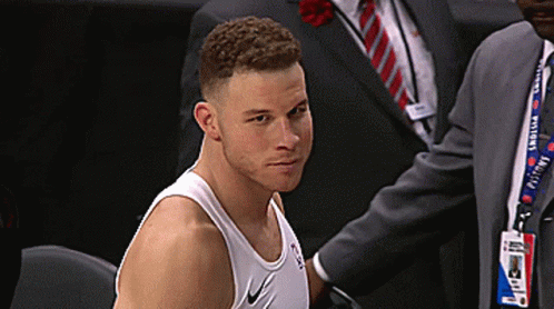 A Man Wearing A Nike Tank Top Is Sitting In A Chair GIF