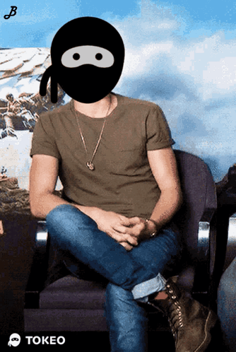 A Man Wearing A Ninja Mask Is Sitting In A Chair With The Word Tokeo Below Him GIF