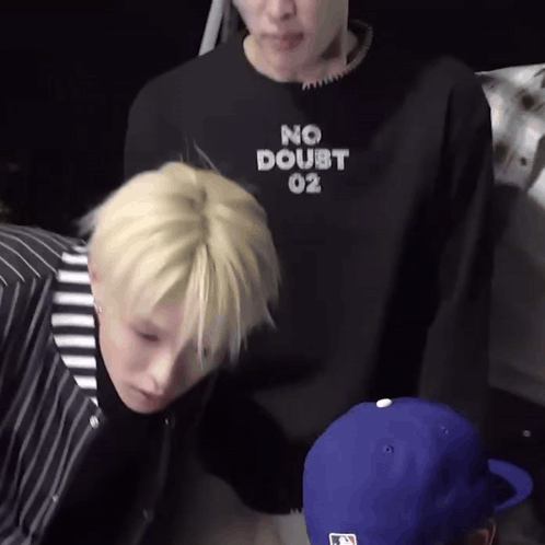 a man wearing a no doubt 02 sweatshirt is standing next to another man
