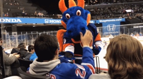 A Man Wearing A Number 22 Jersey Petting A Blue Dragon Mascot GIF