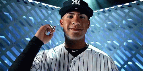 A Man Wearing A Ny Hat And Striped Shirt GIF