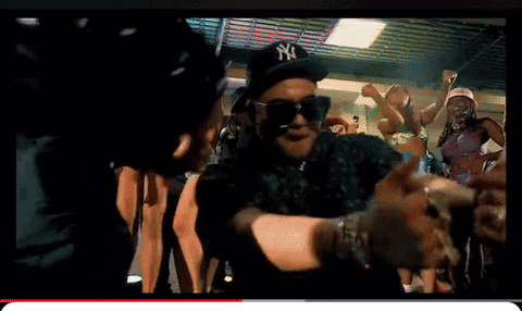 A Man Wearing A Ny Hat And Sunglasses Is Dancing In A Crowd GIF