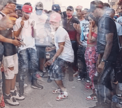 A Man Wearing A Ny Hat Is Dancing In A Crowd GIF