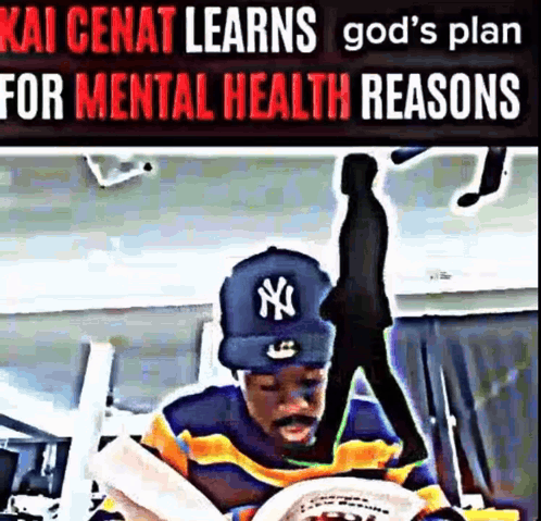 A Man Wearing A Ny Yankees Hat Is Reading A Newspaper . GIF