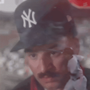A Man Wearing A Ny Yankees Hat Looks Out A Window GIF