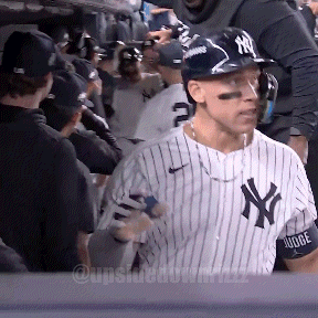 A Man Wearing A Ny Yankees Jersey Stands In A Crowd GIF