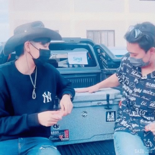 A Man Wearing A Ny Yankees Sweatshirt Sits Next To Another Man GIF