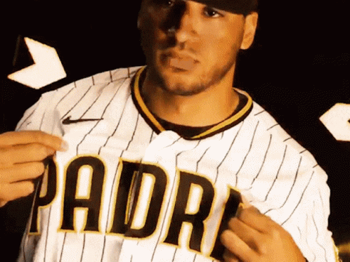 A Man Wearing A Padres Jersey Is Holding A Piece Of Paper GIF