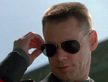 A Man Wearing A Pair Of Aviator Sunglasses Adjusts His Glasses GIF